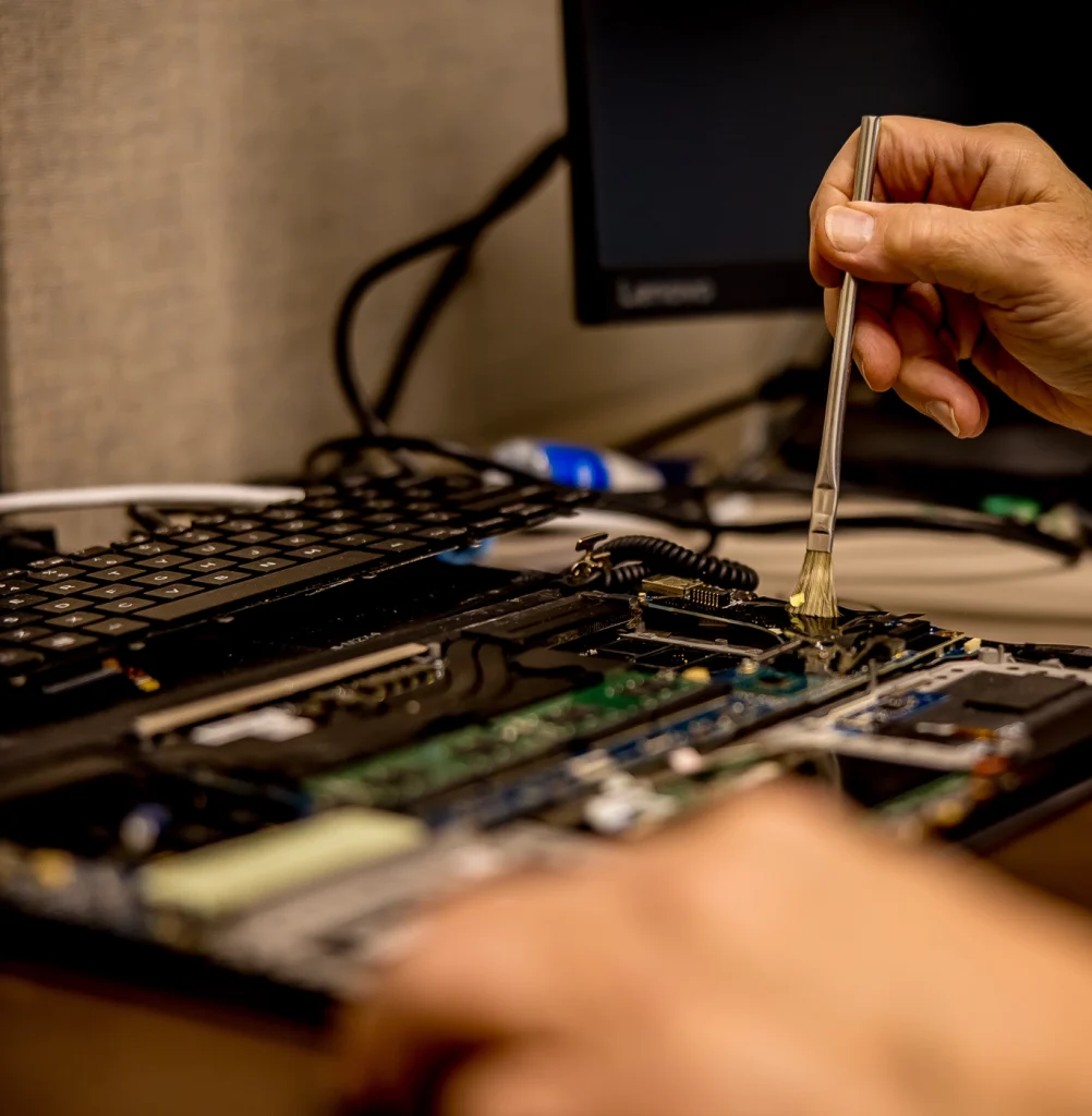 Laptop with the keyboard removed, cleaning the internal hardware of the laptop