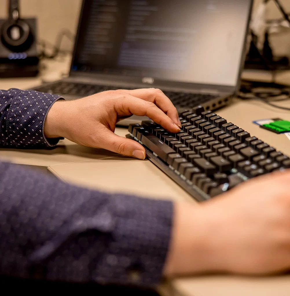 Man working at a desk typing on a keyboard