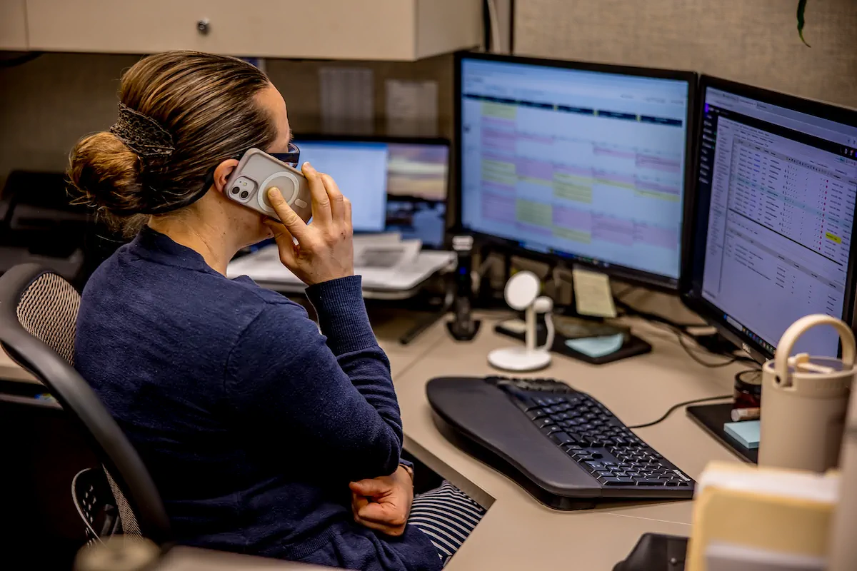 Laurie on the phone at her desk helping clients